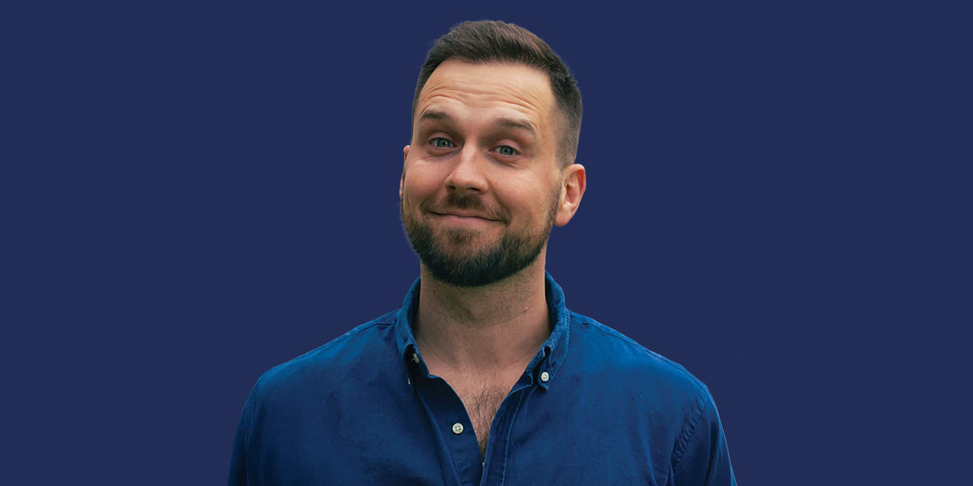 Comedian Trey Kennedy smiling, set against a blue background.
